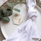 Boho wooden hexagon wedding place setting with napkin and natural foliage