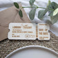 Engraved wooden save the date boarding pass shown with a kraft envelope