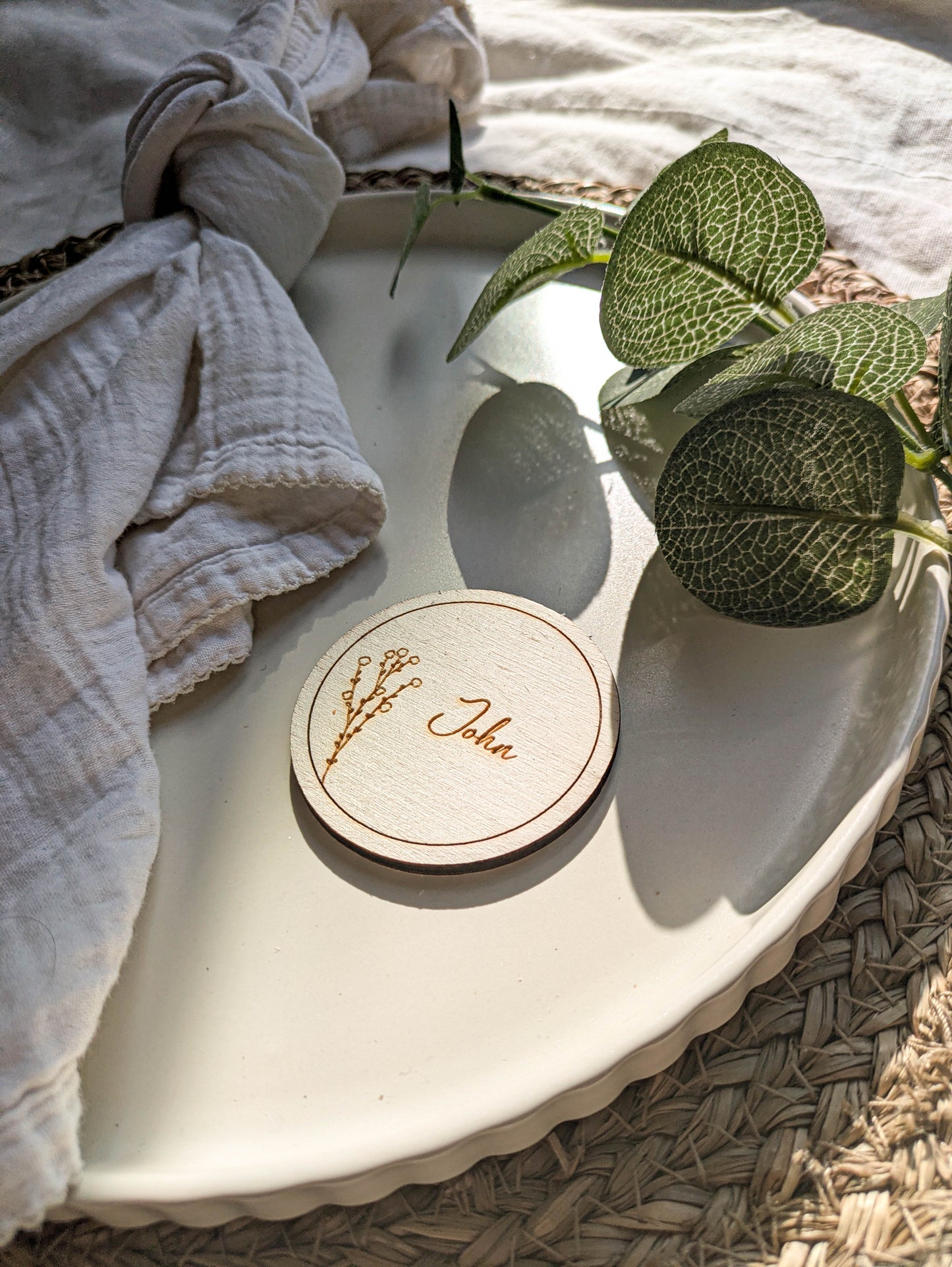 Close up of a laser engraved wooden place name disc