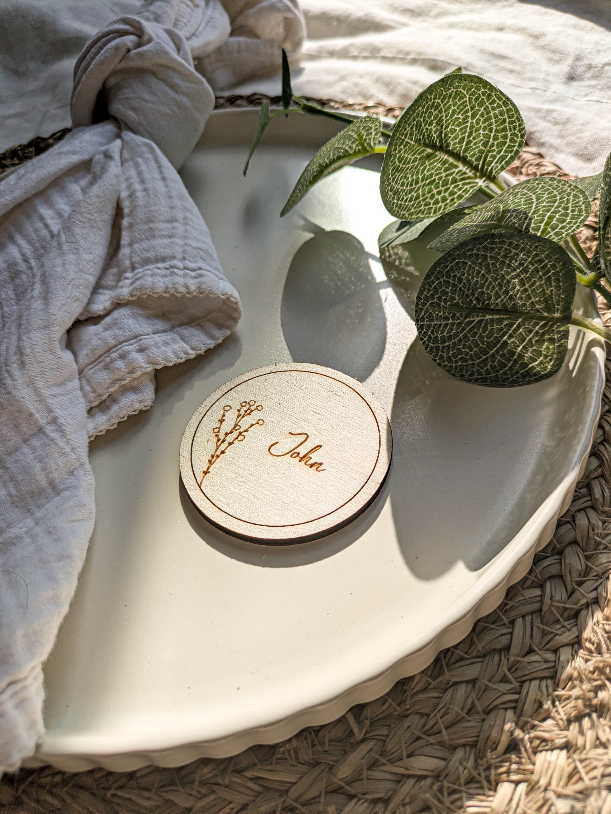Natural wood round place name guest keepsake for a wedding table