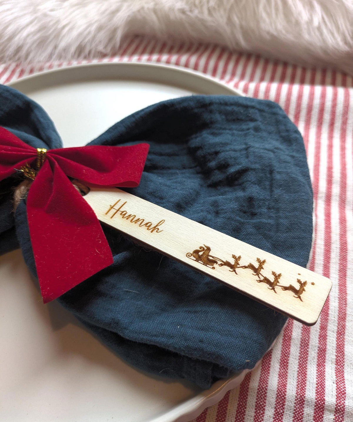 Santa Sleigh design: personalised wooden Christmas place name with Hannah, styled on a napkin