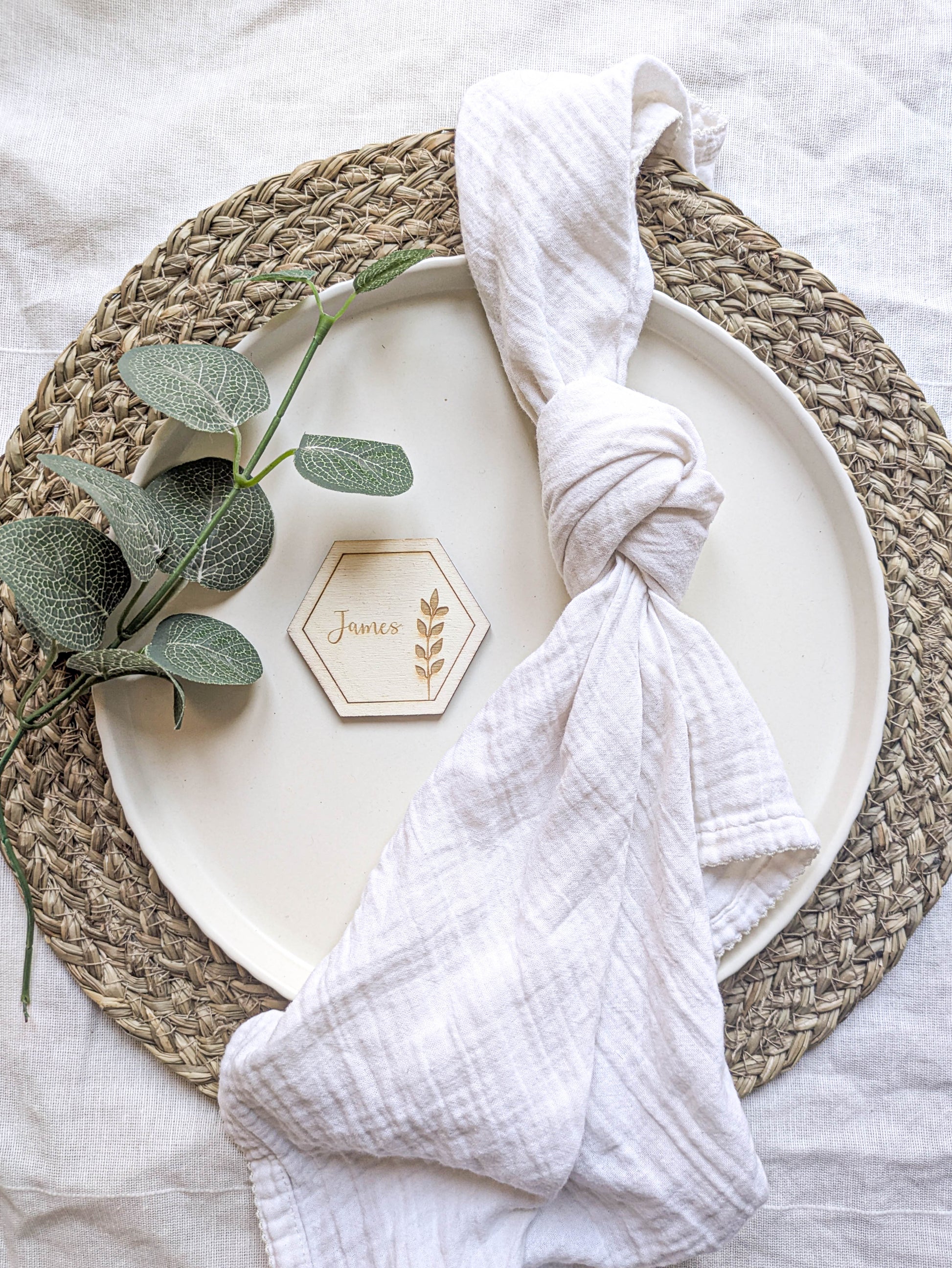 Wooden hexagon wedding place name styled on a plate with a white napkin