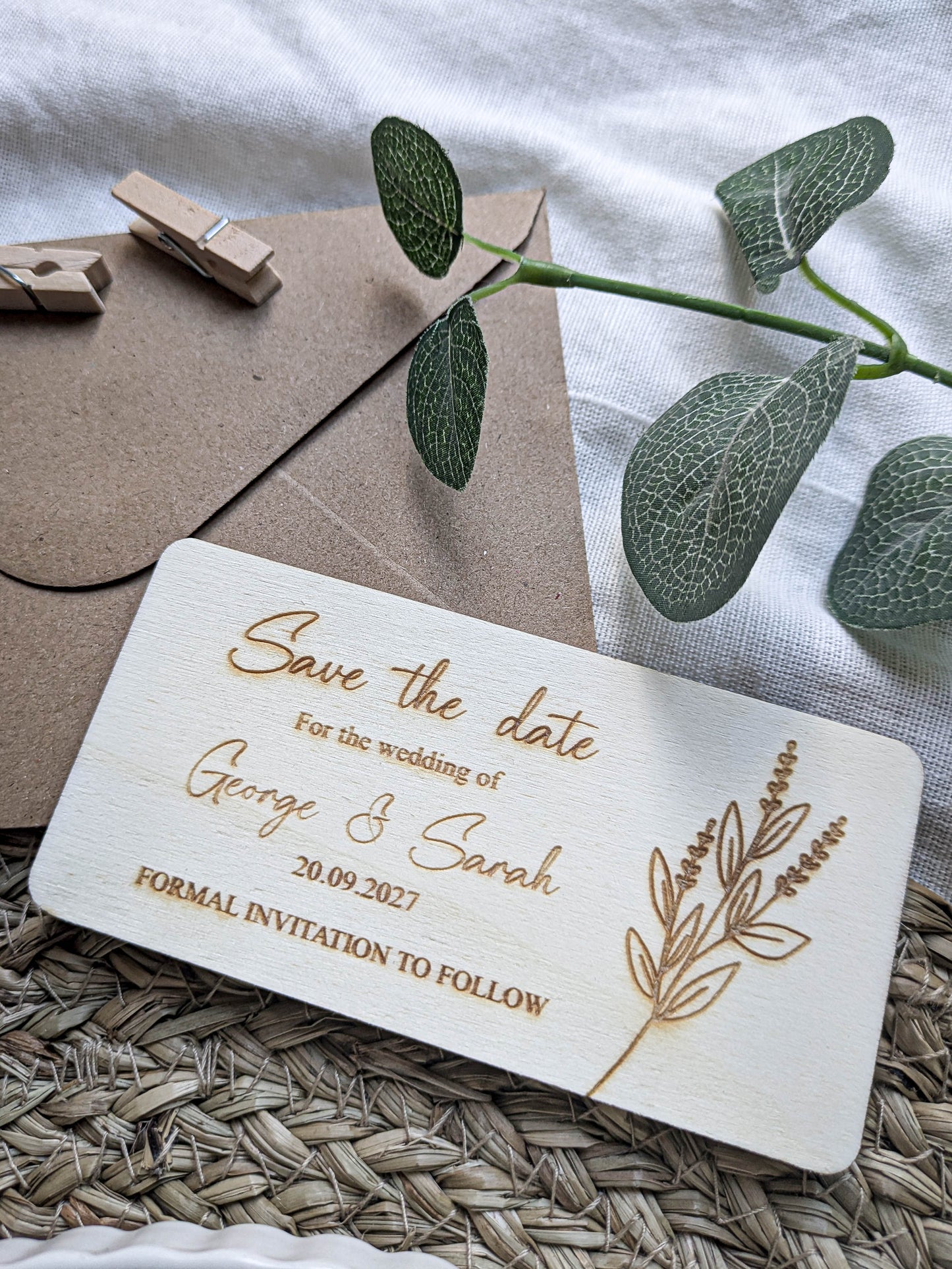 Close up of laser engraved names and date on wooden save the date card
